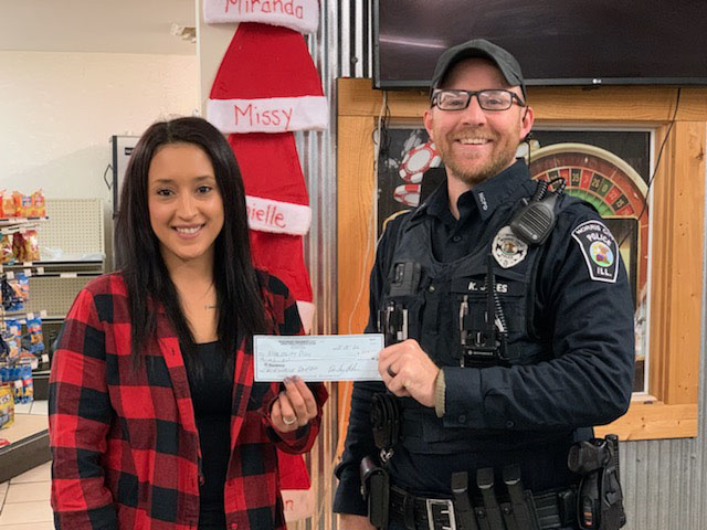 Officer Kody Jones receiving a donation from Kelly's Quick Stop for White County Shop with a Cop Program 
